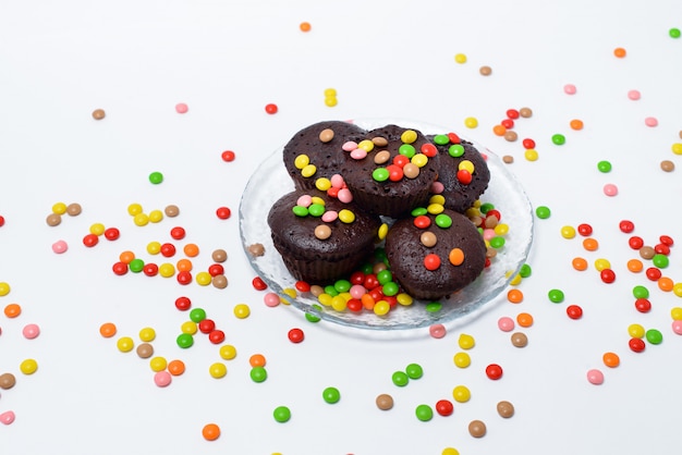 Pastelitos de chocolate y una selección de dulces sobre una superficie negra