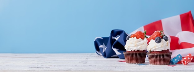 Pastelitos dulces con arándanos y bandera de estados unidos de fresa sobre fondo azul