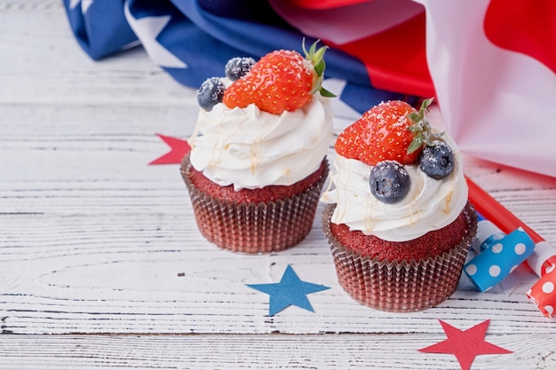 Pastelitos dulces con arándanos y bandera de estados unidos de fresa sobre fondo azul