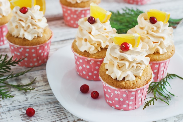 Pastelitos de Navidad con crema batida y arándanos, naranja. Postre de comida festiva.