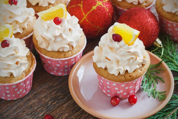 Pastelitos de Navidad con crema batida y arándanos, naranja. Postre de comida festiva.