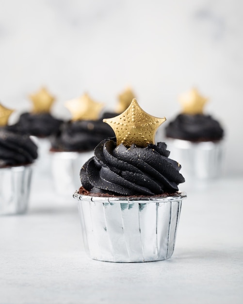 Pastelitos negros decorados con una estrella dorada sobre un fondo claro