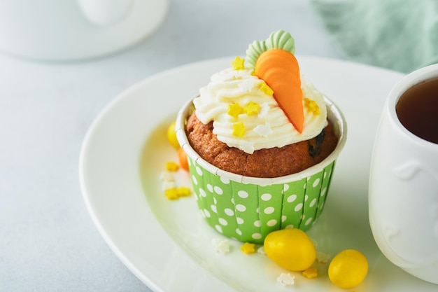 Pastelitos de pastel de zanahoria para Pascua Pastelitos de zanahoria con glaseado de queso crema decorados con pequeñas zanahorias de mazapán sobre fondo blanco Feliz Pascua y concepto de vacaciones de primavera Vacaciones caseras