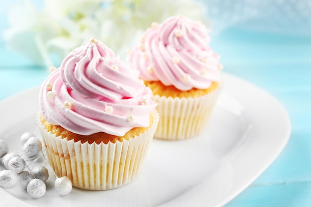 Pastelitos rosas sobre fondo de madera