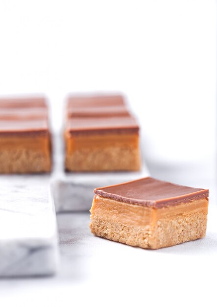 Pastelitos de tarta de caramelo y galleta postre sobre tabla de mármol