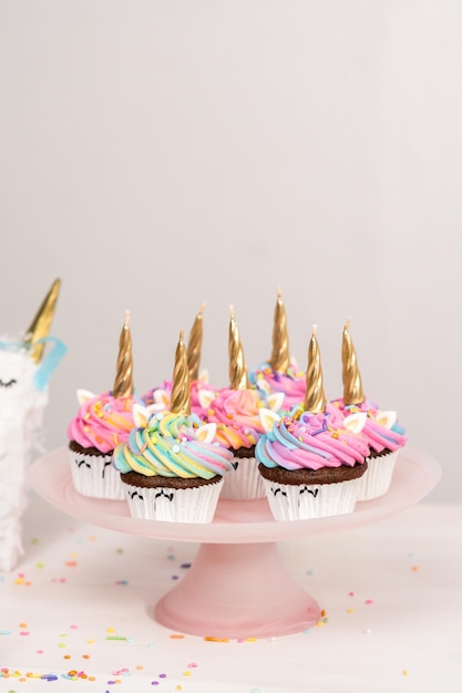 Pastelitos de unicornio decorados con colorido glaseado de crema de mantequilla y chispas.