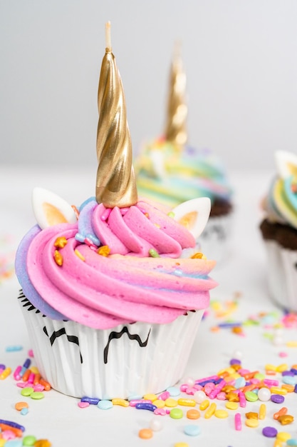 Pastelitos de unicornio decorados con colorido glaseado de crema de mantequilla y chispas.