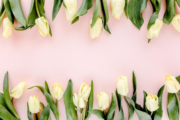 Pastellfarbener und gelber Tulpenblumenstrauß auf rosa Hintergrund, flache Lage, Draufsicht, Valentinshintergrund