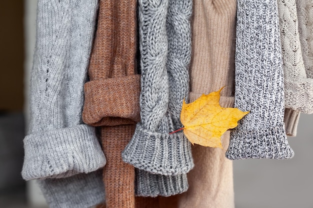 Pastellfarbener warmer Strickpullover, der im Schrank hängt Gemütliche Herbst- und Wintergarderobe