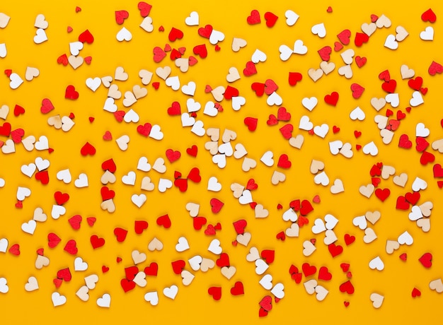 Pastellherzen des Valentinstaghintergrundes auf gelbem Hintergrund. Grußkarte.