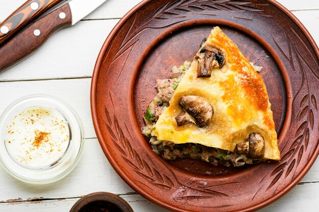 Pastete mit Hackfleisch und Champignons auf Teller. Stück Fleischpastete