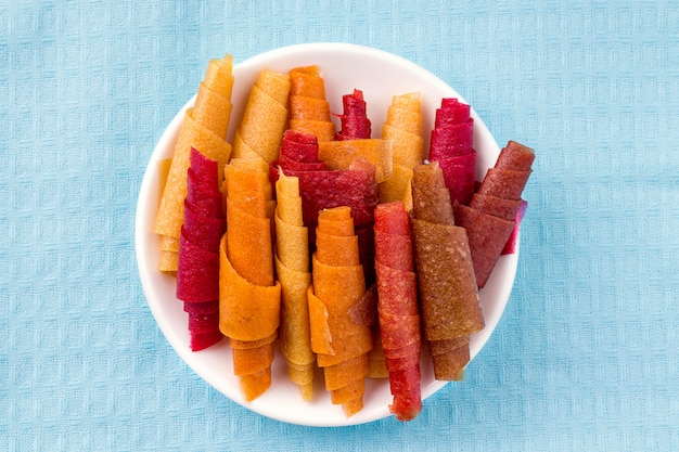 Pastilla, rollitos de fruta sin azúcar sobre tela azul