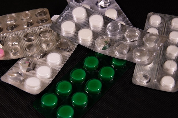 Pastillas antibióticas sobre un fondo negro. Concepto de salud y medicina