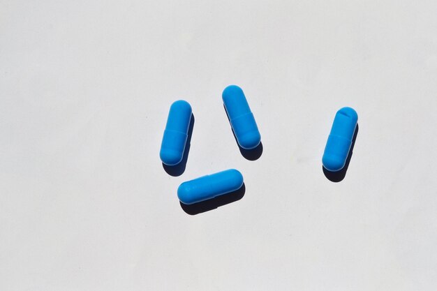 Foto las pastillas azules yacen sobre un fondo blanco.