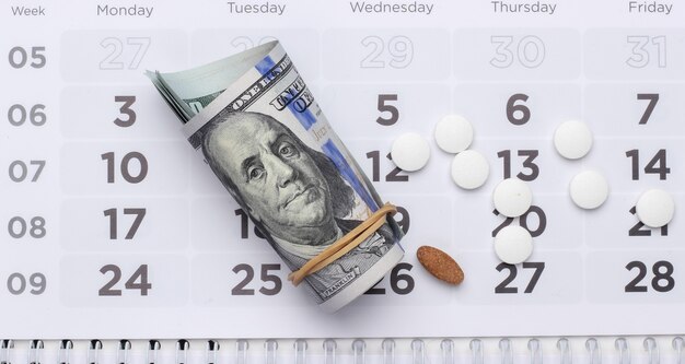 Pastillas con billetes de un dólar en el calendario. Concepto de salud y medicina