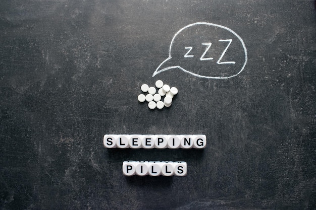 Pastillas blancas en forma de Z pastillas para dormir drogas hipnóticas sedantes melatonina en fondo oscuro