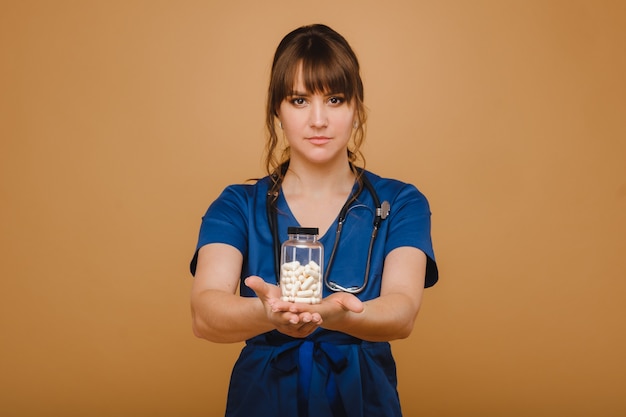 Pastillas blancas en un frasco de una doctora. El médico muestra las cápsulas de vitaminas.