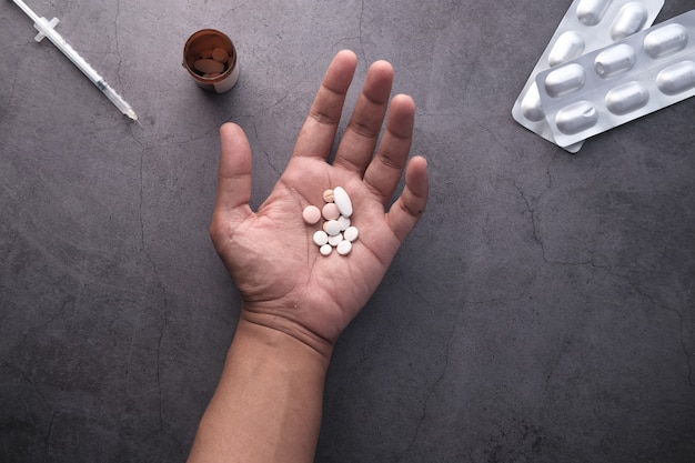 Pastillas blancas en la palma de la mano de arriba hacia abajo