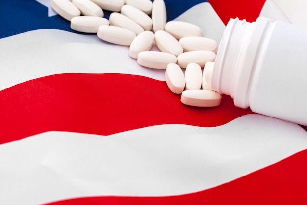 Pastillas blancas recetadas en la bandera de Estados Unidos