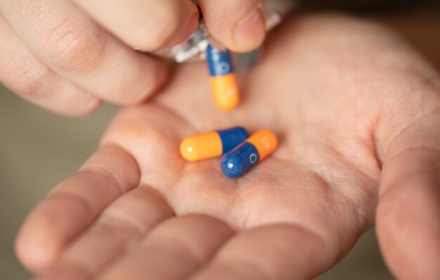 Pastillas de colores y medicinas en la mano