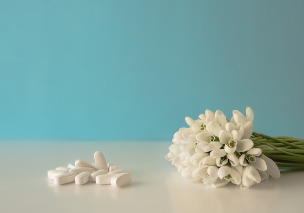 Pastillas derramándose de un bote de pastillas y flores