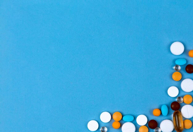 Foto pastillas establecidas como borde. pastillas de colores establecidos como borde sobre fondo azul