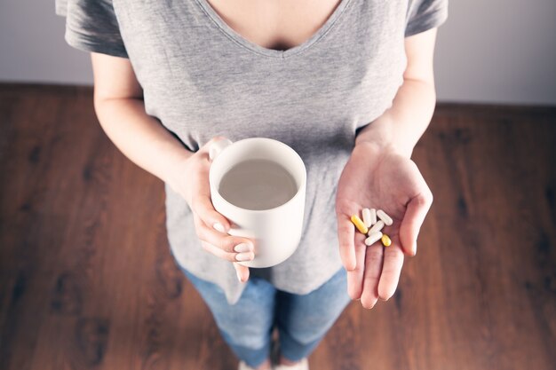 Foto pastillas de explotación de mano de mujer closeup