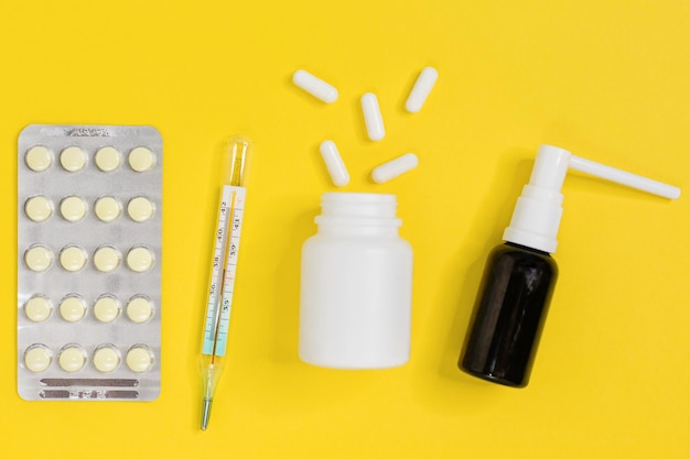 Pastillas para la gripe o el frio termómetro pastillas blancas de la botella y spray para la garganta plana