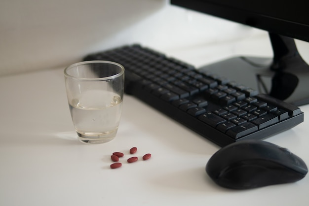 pastillas en el lugar de trabajo o en el escritorio de la oficina para aliviar la migraña por estrés