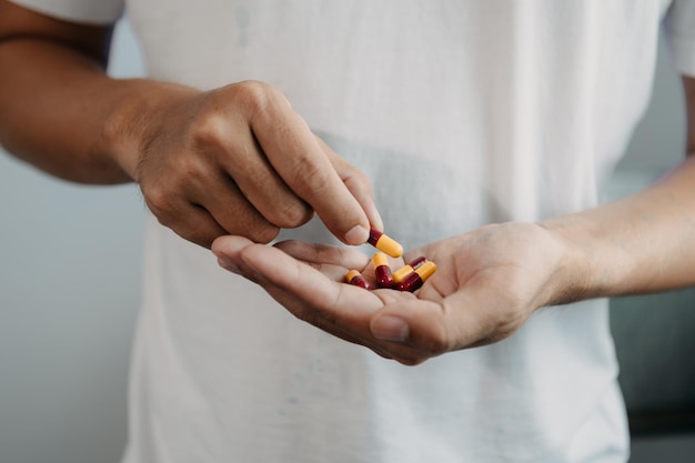 pastillas en las manos de las personas de edad avanzada dolorosa edad joven cuidado de la salud de los ancianos