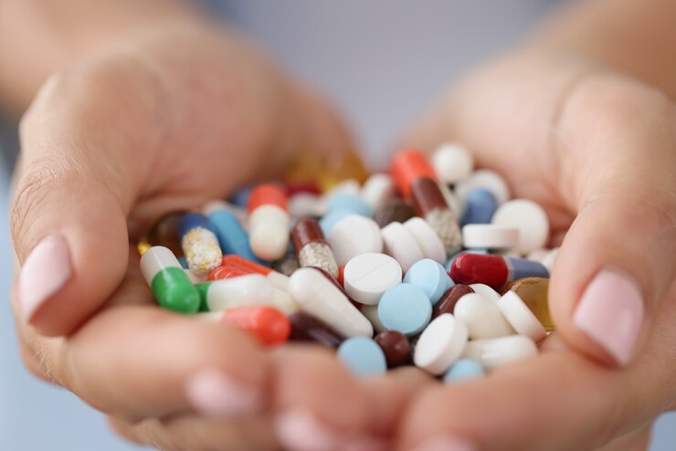 Foto pastillas médicas multicolores en manos femeninas closeup