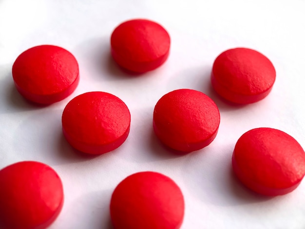 Pastillas redondas de color rojo aisladas sobre fondo blanco. Concepto de salud.