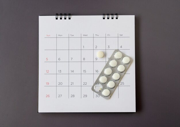 Pastillas sobre un fondo de calendario. concepto de salud