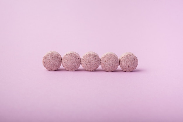 Pastillas sobre un fondo rosa. Aditivos biológicamente activos