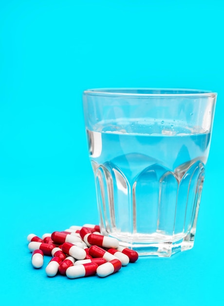 Pastillas con vaso de agua en azul.