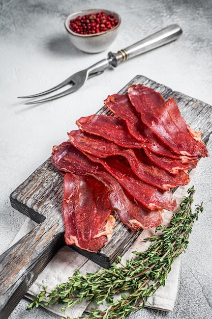 Pastirma Türkisch geschnittenes Pastrami getrocknetes Rindfleisch mit Gewürzen auf Holzbrett Weißer Hintergrund Ansicht von oben