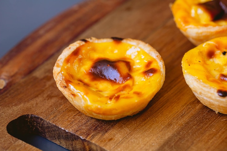 Foto pastis de belm ou pastis de nata em uma placa de madeira pronta para comer