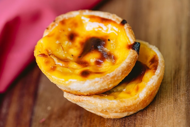 Pastis de Belm ou Pastis de Nata em uma placa de madeira pronta para comer