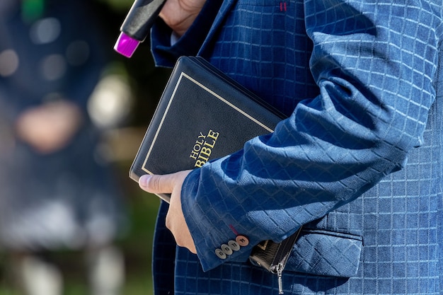 Pastor con una biblia en la mano durante un sermón. el predicador pronuncia un discurso