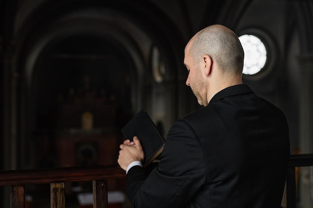 Pastor con biblia rezando en la iglesia