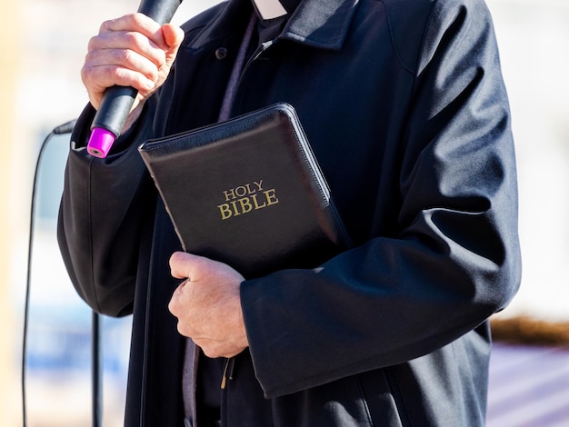 Pastor com uma bíblia na mão durante um sermão. o pregador faz um discurso