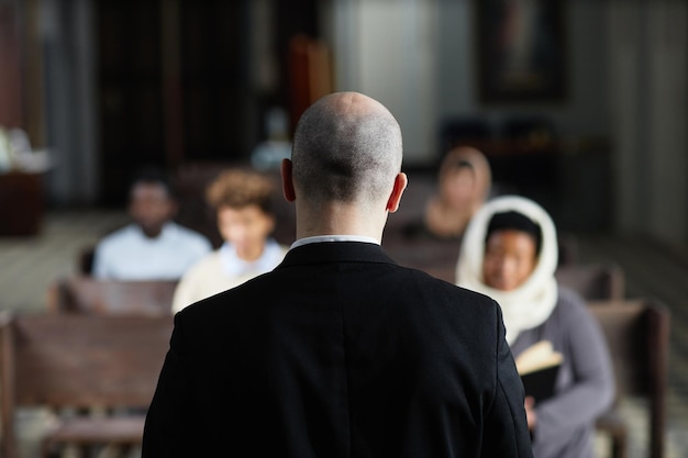 Pastor spricht mit Gläubigen in der Kirche