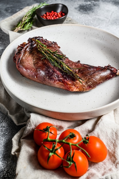 Pata de conejo al horno con hierbas, servida en servilleta textil.