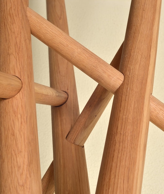 Patas de mesa de madera aisladas sobre fondo gris Cerrar vista foto piernas cruzadas en forma de estrella elementos de muebles ecológicos de madera Muebles de madera maciza construcción complicada