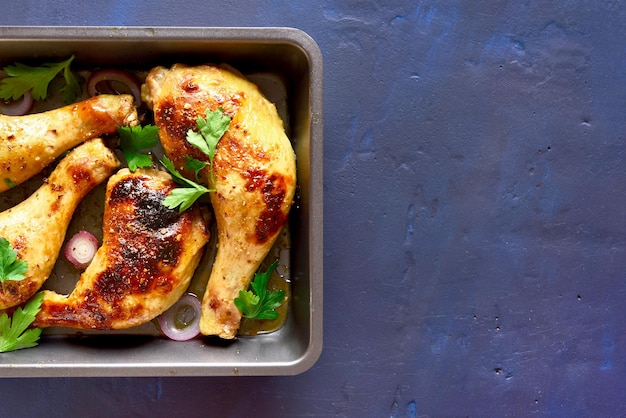 Patas de pollo asadas en sartén sobre fondo de piedra azul con espacio de copia Vista superior