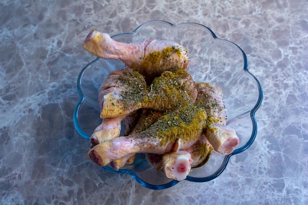 Patas de pollo crudas mezcladas con varias especias. Los muslos de pollo crudos están preparados para ser cocinados.