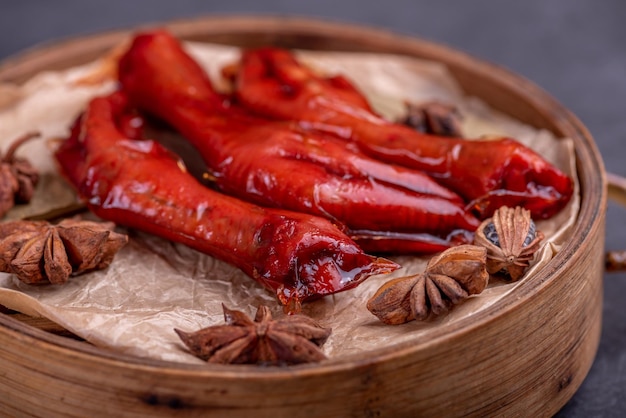 Las patas de pollo guisado están en el recipiente en el fondo oscuro