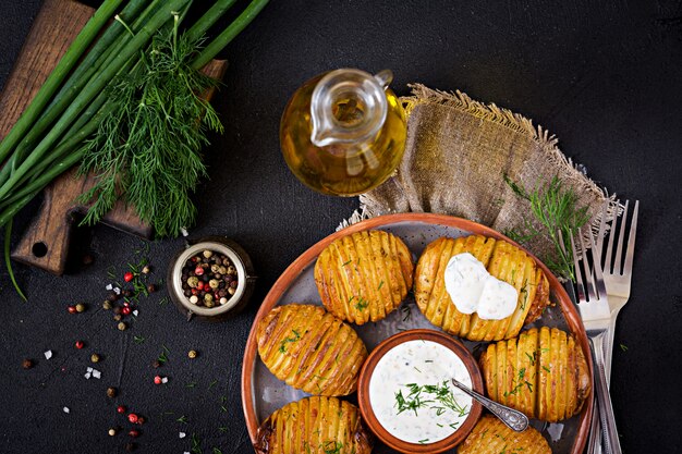 Patata al horno con hierbas y salsa en mesa negro. Comida vegana. Comida saludable. .