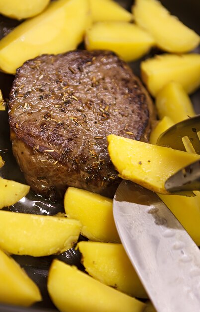 Patata al horno con un trozo de ternera.