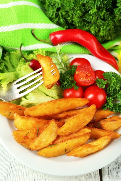 Patata frita casera en un plato sobre fondo de madera